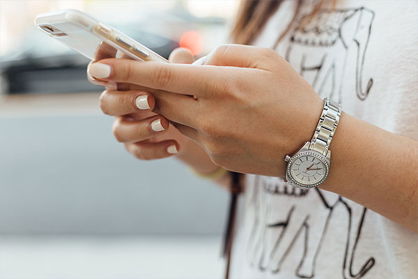 Frauenhände halten ein Smartphone